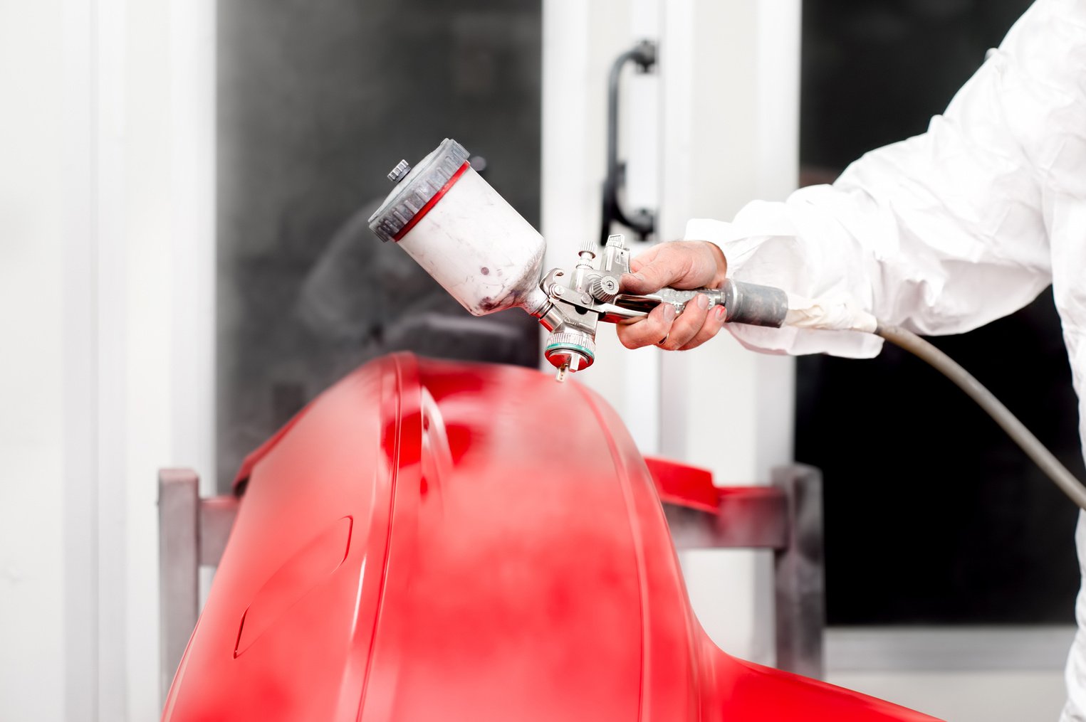 Automotive industry - engineer working on painting a red car